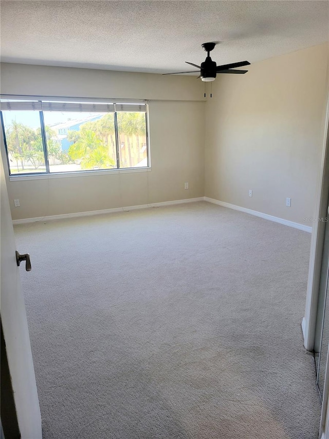 unfurnished room with ceiling fan, a textured ceiling, and carpet flooring