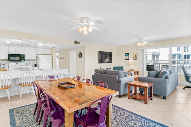 tiled dining room with ceiling fan, sink, and track lighting