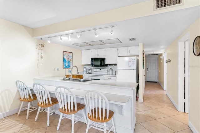 kitchen with white cabinetry, sink, a kitchen breakfast bar, kitchen peninsula, and white appliances