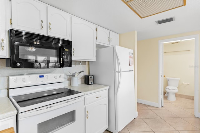 kitchen with white appliances, white cabinetry, and light tile patterned flooring