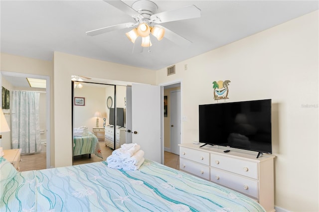 bedroom with ensuite bath, ceiling fan, and a closet