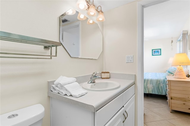 bathroom with tile patterned flooring, vanity, and toilet