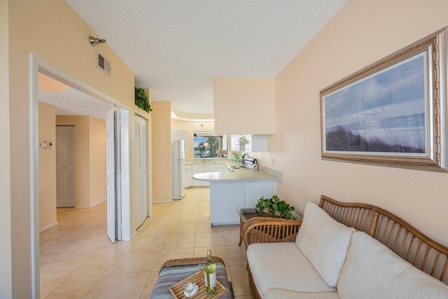 tiled living room with sink and a textured ceiling