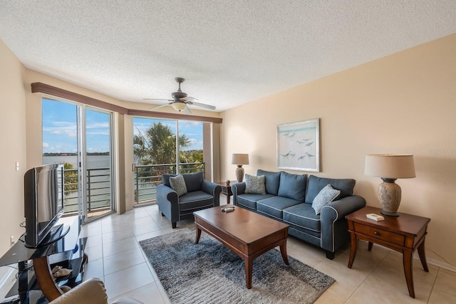 tiled living room with ceiling fan and a textured ceiling