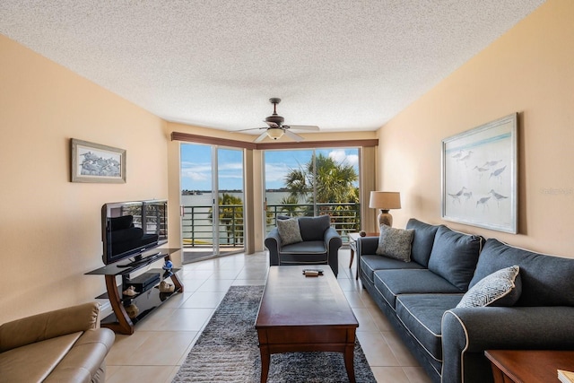 tiled living room featuring ceiling fan and a textured ceiling