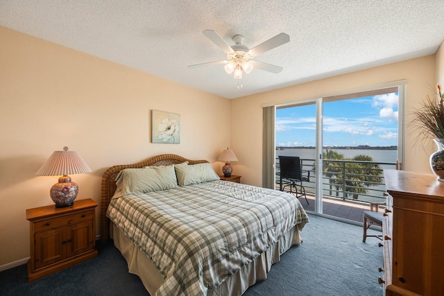 carpeted bedroom featuring access to exterior, a textured ceiling, ceiling fan, and a water view