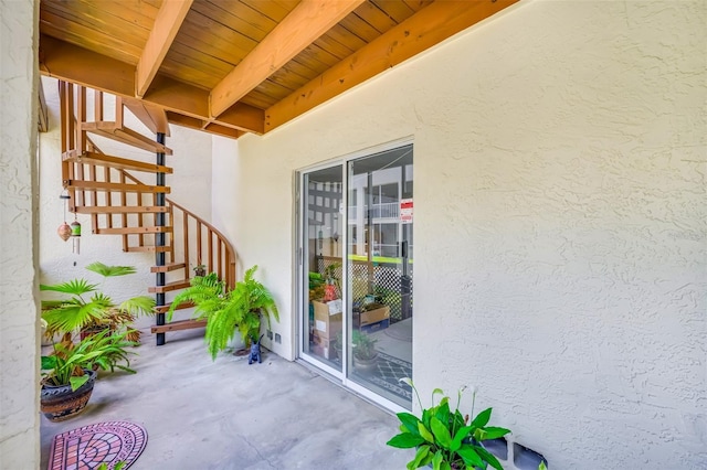 view of exterior entry with a patio area and stucco siding