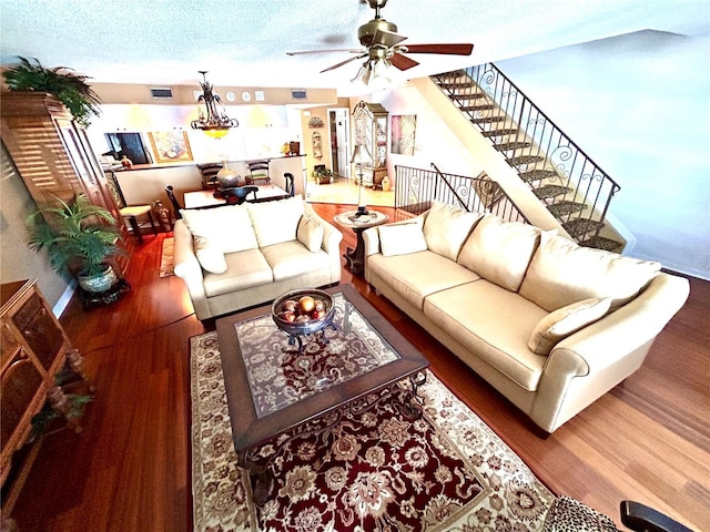 living room featuring visible vents, ceiling fan, a textured ceiling, wood finished floors, and stairs