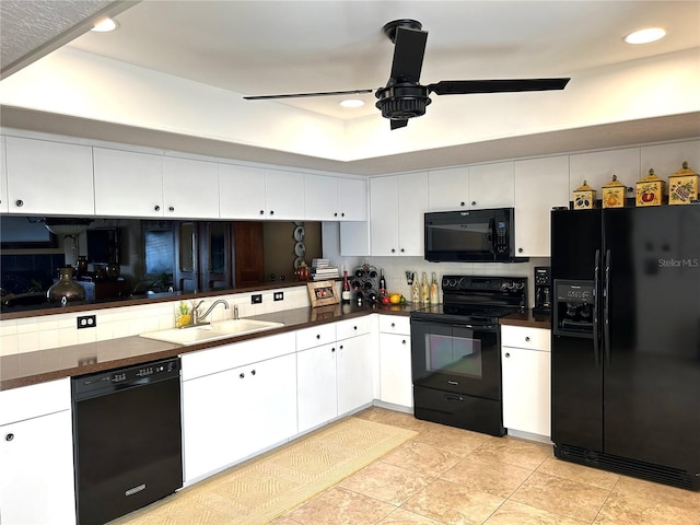 kitchen with dark countertops, black appliances, white cabinetry, and a sink