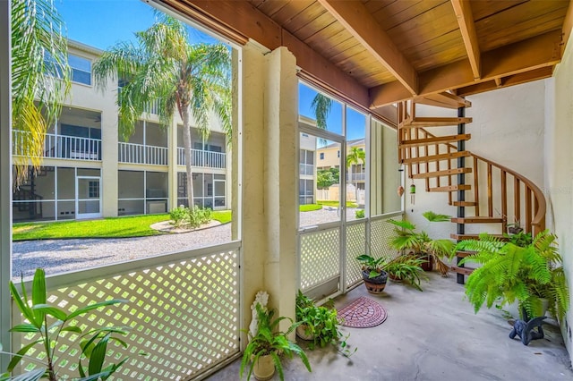 unfurnished sunroom with beamed ceiling