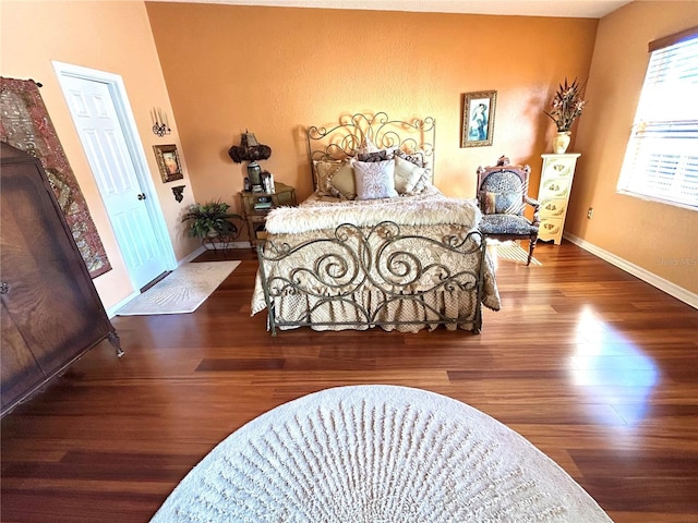 bedroom with baseboards and wood finished floors