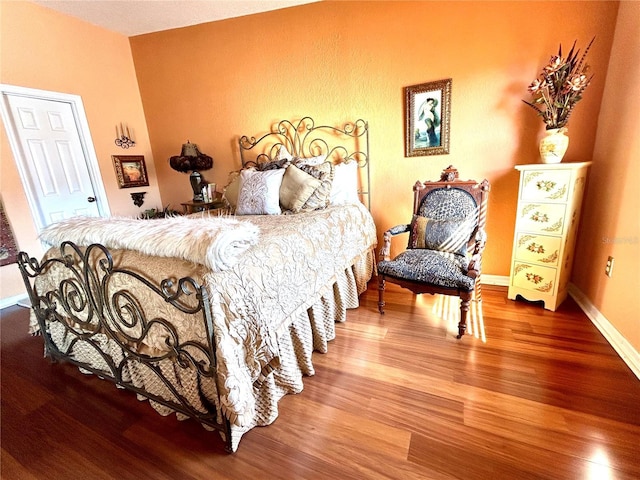 bedroom with wood finished floors and baseboards