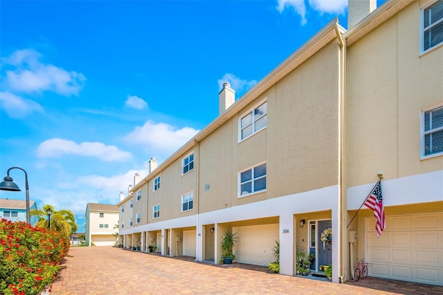 view of building exterior with driveway and an attached garage