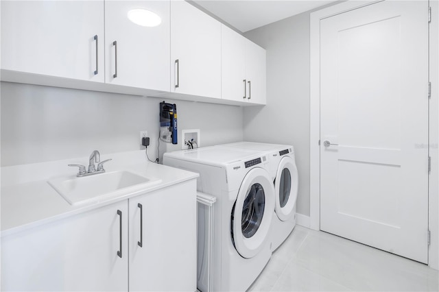 laundry area featuring washer and dryer, cabinets, light tile patterned floors, and sink