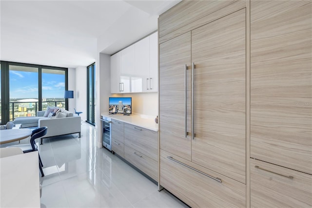 kitchen with wine cooler, white cabinetry, and light tile patterned floors