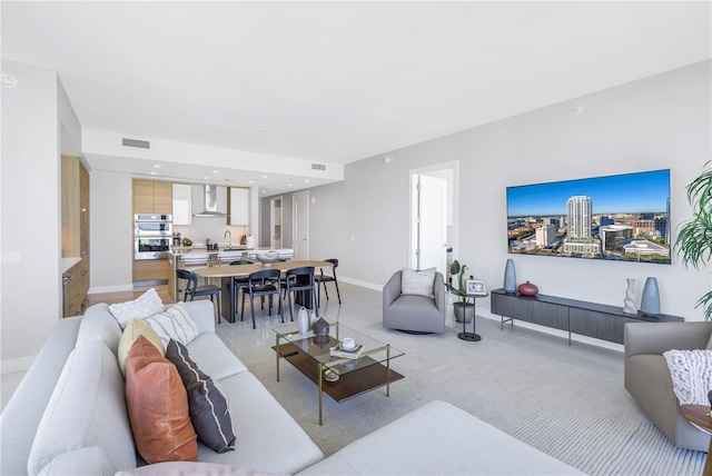 living room with light carpet and sink