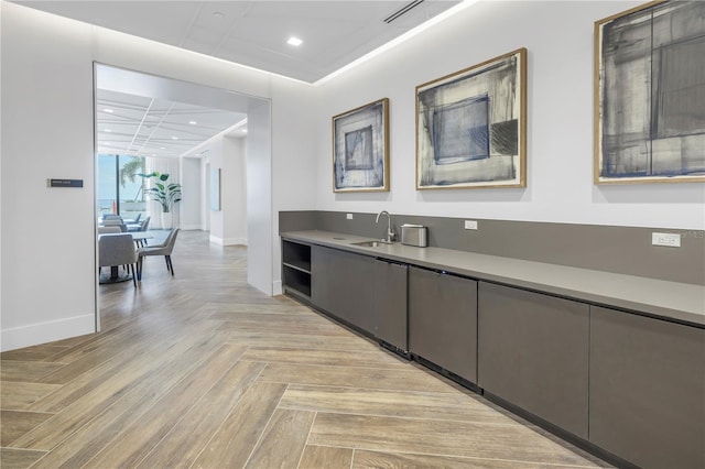 bar featuring light parquet floors and sink