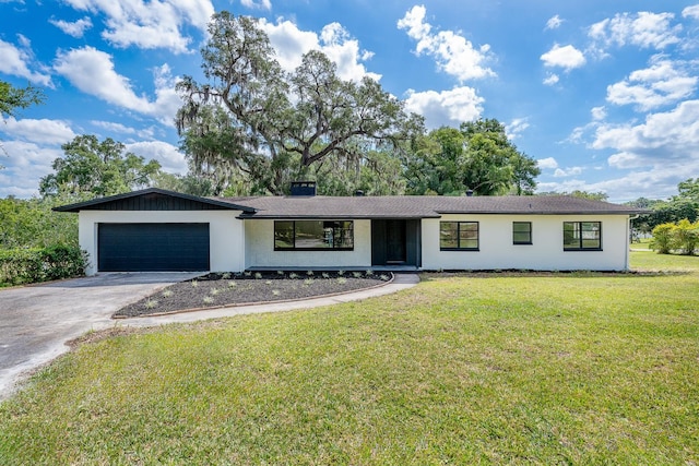 ranch-style house featuring a garage and a front lawn