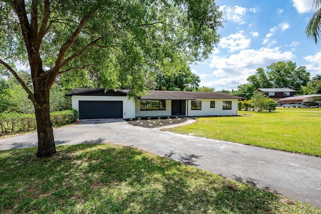 single story home featuring a garage and a front yard