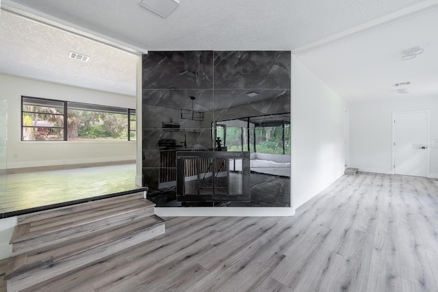 interior space with a textured ceiling and light hardwood / wood-style floors