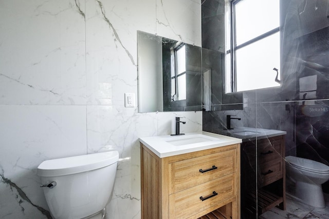 bathroom featuring vanity, a healthy amount of sunlight, tile walls, and toilet