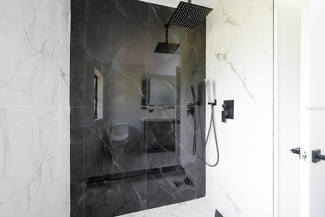 bathroom with tiled shower and toilet