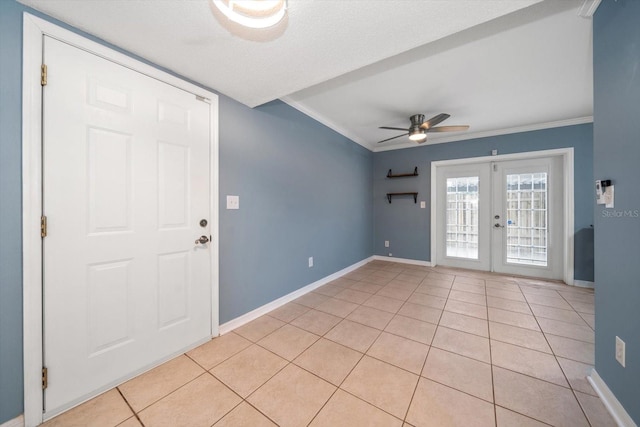 tiled entrance foyer featuring a textured ceiling, ceiling fan, french doors, and crown molding