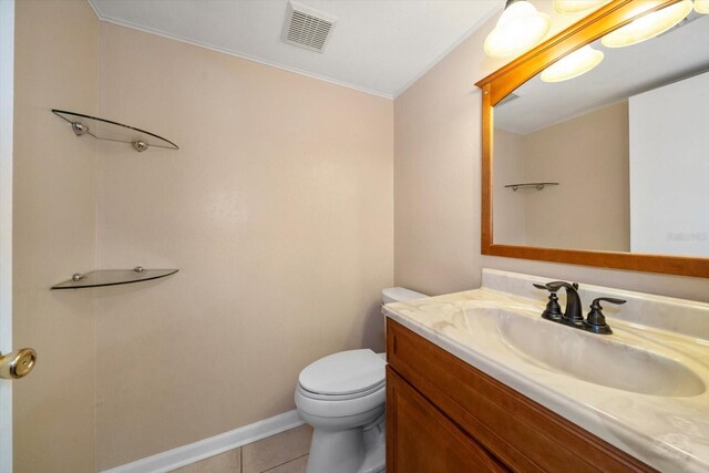 bathroom with tile flooring, toilet, and vanity