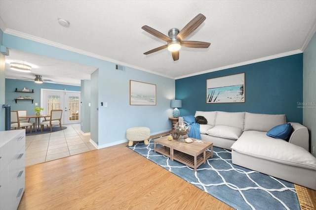 living room with ceiling fan, french doors, crown molding, and light tile flooring