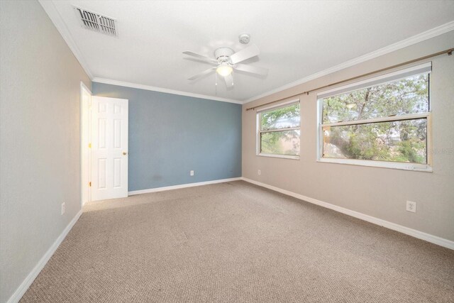 carpeted spare room with ceiling fan and crown molding