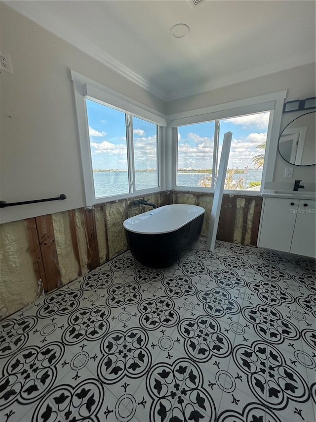 bathroom with a bath, vanity, and a water view