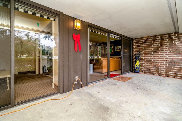 view of exterior entry with a patio area