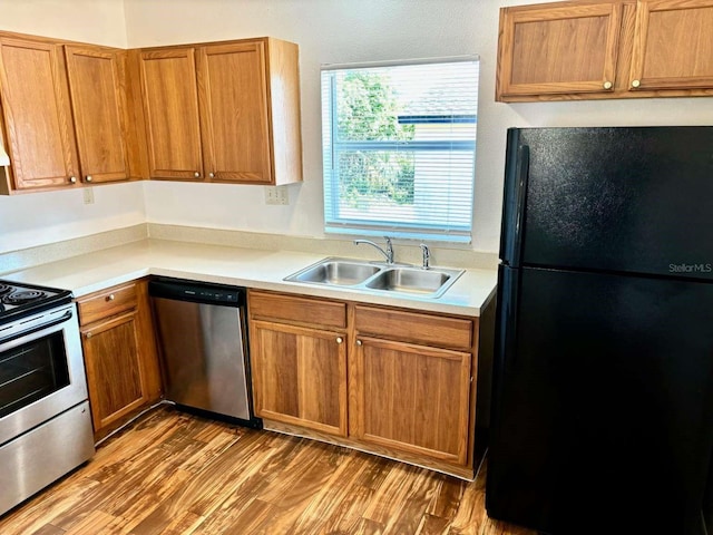 kitchen with stainless steel appliances, light hardwood / wood-style floors, and sink