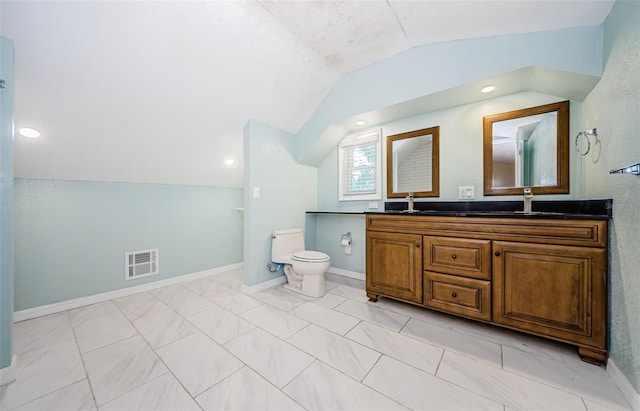 bathroom with lofted ceiling, vanity, and toilet