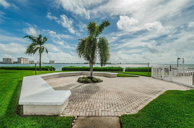 view of community featuring a patio, a yard, and a water view