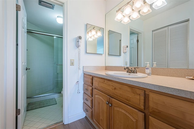 bathroom with an enclosed shower, vanity, and hardwood / wood-style floors