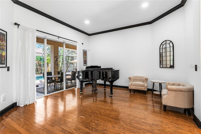 living area featuring hardwood / wood-style flooring and ornamental molding