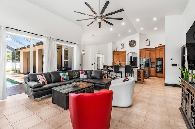 living room with ceiling fan, high vaulted ceiling, and light tile patterned floors