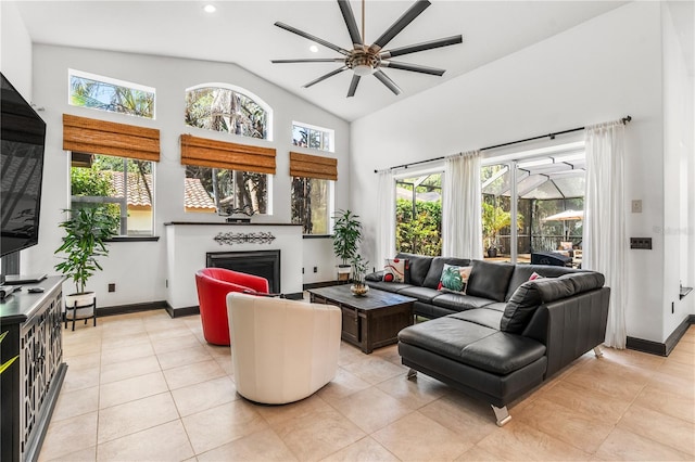 tiled living room with plenty of natural light, ceiling fan, and high vaulted ceiling