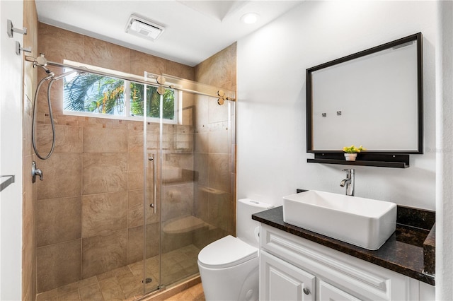 bathroom with vanity, toilet, and a shower with shower door