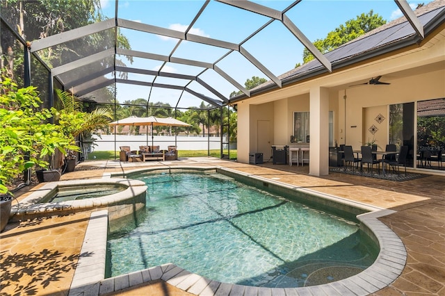 view of pool with a lanai, ceiling fan, an in ground hot tub, and a patio