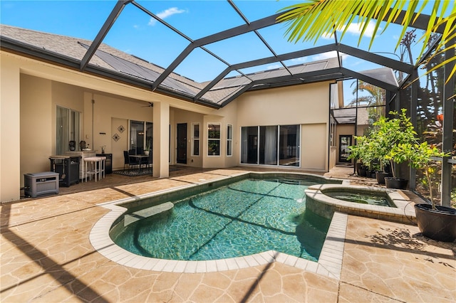 rear view of house featuring glass enclosure, a swimming pool with hot tub, a patio, and an outdoor bar