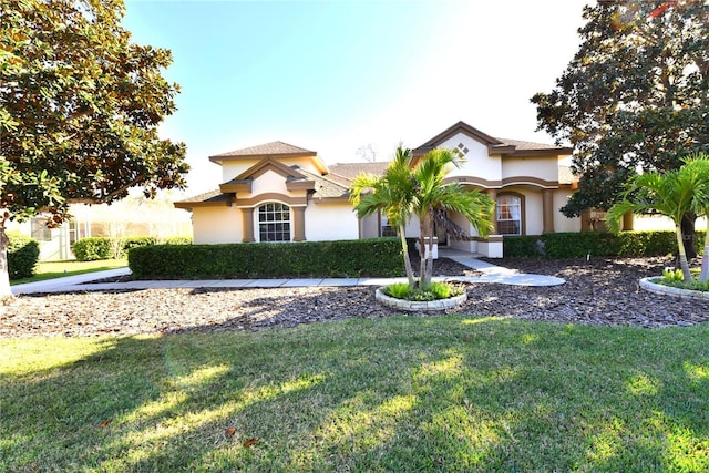 mediterranean / spanish home with a front yard