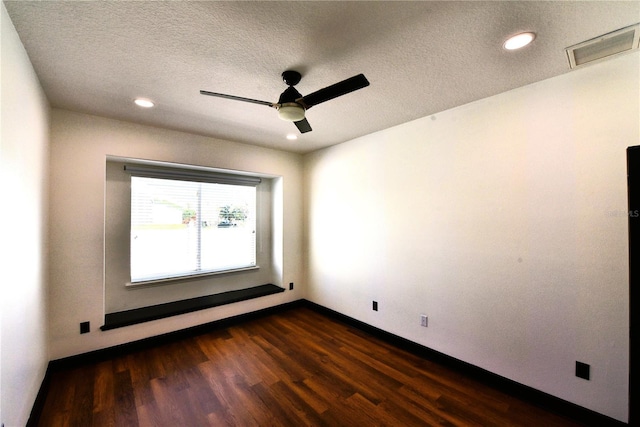 spare room with dark hardwood / wood-style flooring, ceiling fan, and a textured ceiling