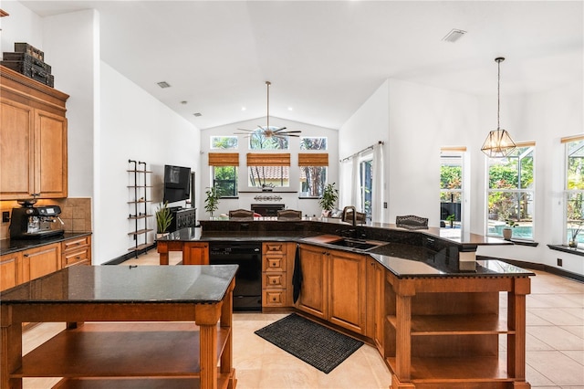 kitchen with sink, a kitchen island with sink, dark stone countertops, hanging light fixtures, and black dishwasher