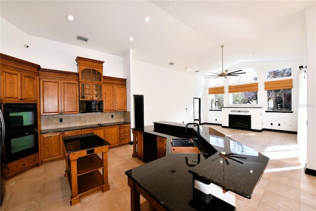 kitchen featuring a spacious island, sink, tasteful backsplash, vaulted ceiling, and black double oven