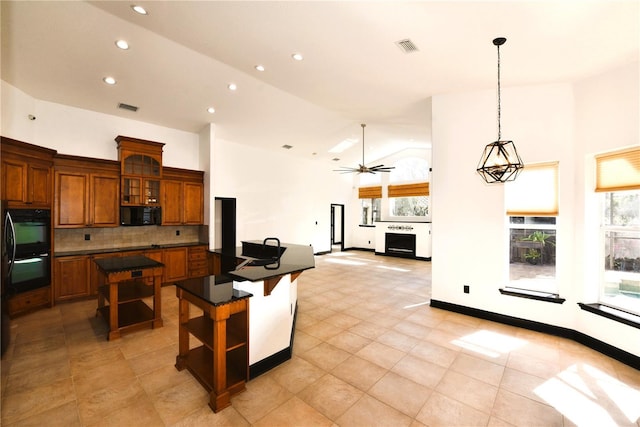 kitchen with ceiling fan, high vaulted ceiling, a kitchen breakfast bar, a kitchen island, and decorative backsplash