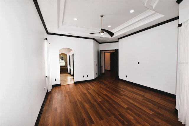 unfurnished bedroom with crown molding, a tray ceiling, and dark hardwood / wood-style floors