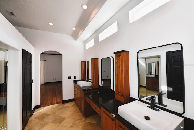 bathroom with vanity and a towering ceiling