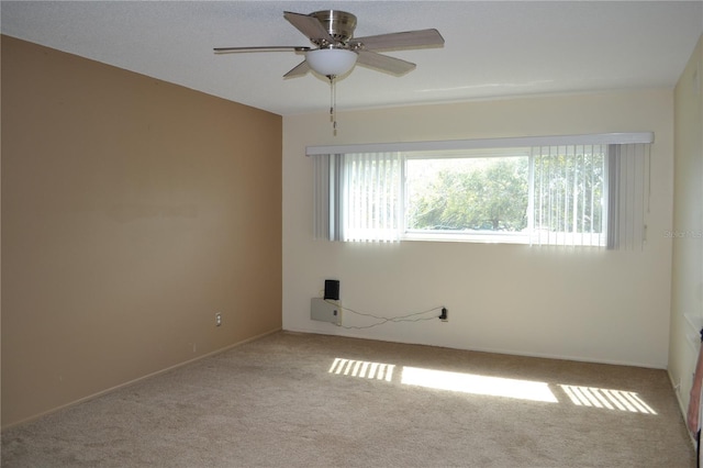 carpeted empty room featuring ceiling fan and a wealth of natural light